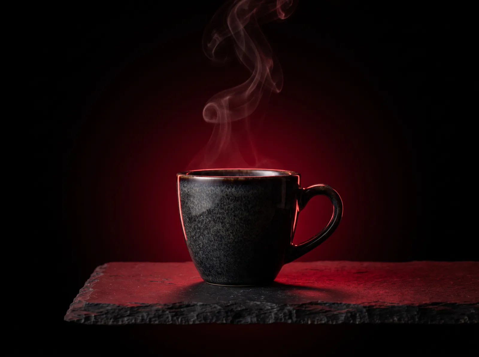 An espresso cup with steam in red rim light